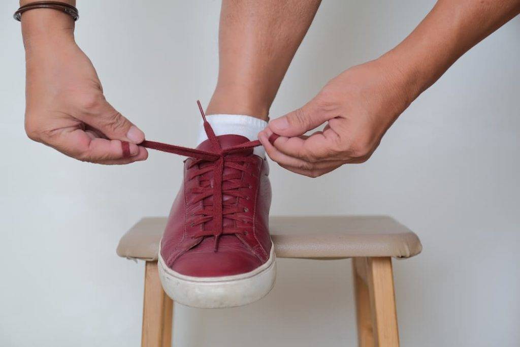 tying shoe laces on a footstool